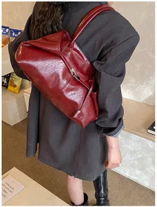 Detail of burgundy vintage tote bag with oil wax leather texture and shoulder strap
