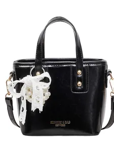 Elegante borsa a secchiello nera lucida con ciondolo di perle e borchie dorate