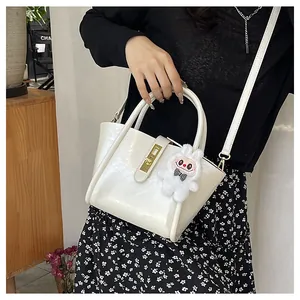 Détail du sac seau blanc avec fermoir tournant doré et pendentif lapin en peluche