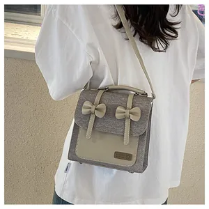 Détail du sac cabas en toile avec nœuds en cuir et écusson fait main de la marque