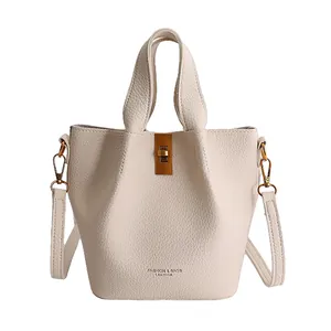 Chic beige bucket bag with lychee pattern leather and gold twist lock closure