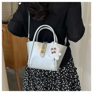 Détail du sac seau plissé argenté avec texture métallique et breloque lapin en peluche