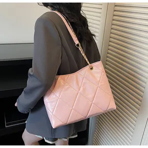 Close-up of pink quilted leather tote featuring golden chain strap and refined stitching
