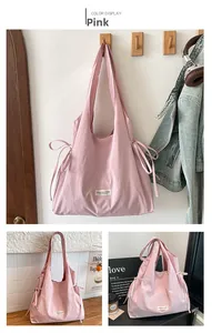 Detail der rosa Nylon-Tragetasche mit seitlichen Kordelzug-Schleifen und Webetikett