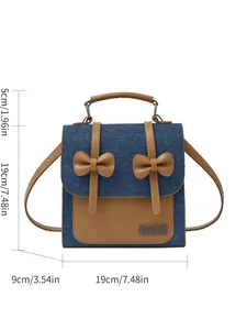 Sac à dos en jean bleu et cuir marron avec nœuds décoratifs et dimensions de 19 cm