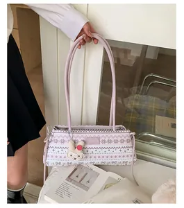 Détail du sac à main en tricot rose avec motifs de flocons et charm lapin en peluche