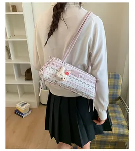 Détail du sac Boston à motifs rose et blanc avec un joli charme de lapin en peluche