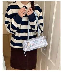Gros plan d'un sac Boston bleu clair avec motifs poney et pendentif lapin mignon