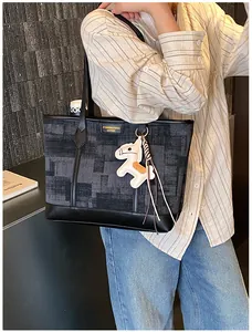 Dettaglio della borsa tote grande con motivo geometrico, finiture in pelle e ciondolo