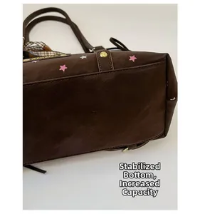 Close-up of structured wide bottom and decorative star pattern on brown tote bag