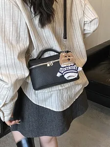 Bolso de caja negro minimalista con textura de lichi y colgante de peluche de perrito