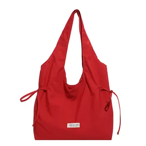 Große rote Canvas-Tragetasche mit Tunnelzug-Details und minimalistischem Markenetikett