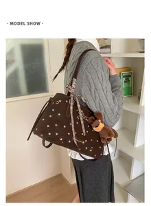 Detail of dark brown tote bag with colorful stars, plaid bow and plush dog charm