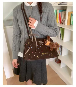 Detail of dark brown tote bag with star print, puppy charm and decorative ribbon