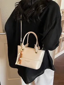 Borsa a secchiello beige stile Maillard in ecopelle con manico e ciondolo di perline
