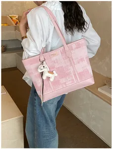 Dettaglio della borsa tote a scacchi rosa con manici in pelle e ciondolo a cavallo