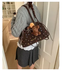 Detail of dark brown canvas tote bag with star patterns and plush puppy charm accessory