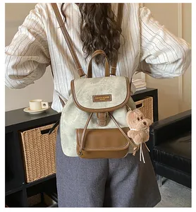 Detail of vintage canvas tote with leather trim, bear charm, and adjustable straps
