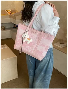 Dettaglio borsa shopper a quadri rosa con logo in metallo e ciondolo a forma di cavallo