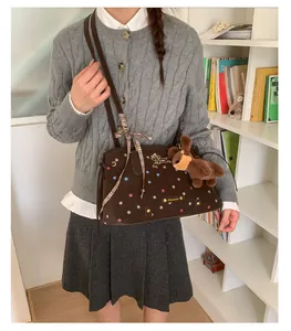 Brown tote bag with colorful stars and dog charm shown in a lifestyle scene