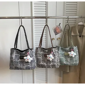 Detailed view of geometric tote bags in black, brown and green with woven rope handles