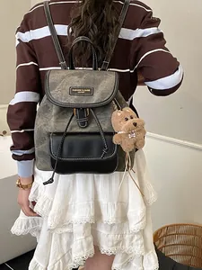 Chic grey and black leather backpack with contrast stitching and plush dog charm