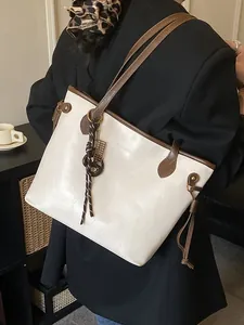 Schicke beige-braune Leder-Tragetasche mit Abakus-Anhänger an der Schulter