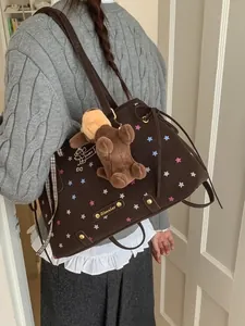 Large dark brown canvas tote bag with puppy prints and plush toy charm on shoulder strap