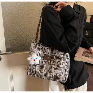 Detail of canvas tote bag with geometric stripes and star plush charm on model