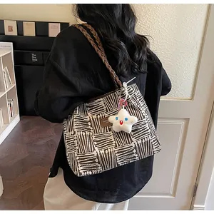 Detail of striped canvas tote bag with woven shoulder strap and cute star charm