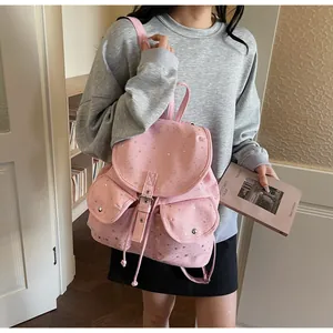 Close-up of pink star pattern backpack with flap closure and decorative buckles