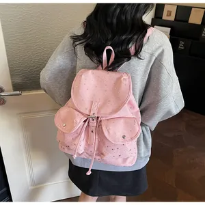 Detail of pink backpack with star patterns, multi-pocket design and leather straps