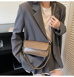 Chic light brown vintage baguette bag styled with gold chain and thin shoulder strap