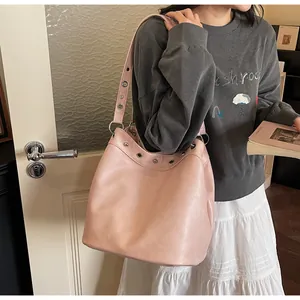 Close-up of pink leather tote bag with silver eyelets and adjustable strap detail