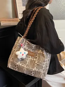 Brown jacquard tote bag with woven shoulder strap and star charm shown in lifestyle setting