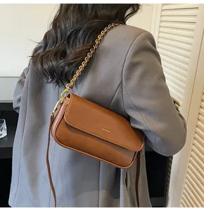 Detail of vintage brown leather bag with NO FILTER gold lettering and chain strap