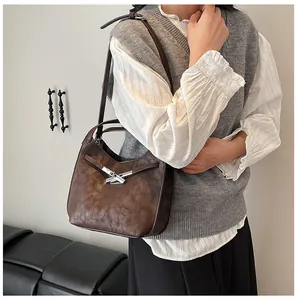 Detail of dark brown vintage shoulder bag with textured leather and silver twist lock