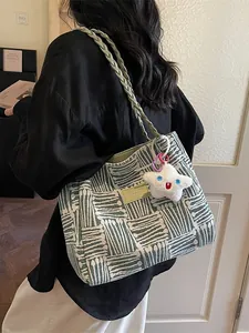 Minimalist woven tote bag in light green and cream with star plush charm on shoulder
