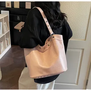 Detail view of pink leather tote bag with stylish silver metal eyelets and wide shoulder strap