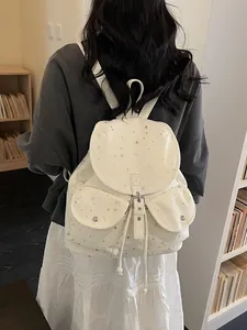 Chic cream tote backpack with silver stars, flap closure, and a stylish campus vibe