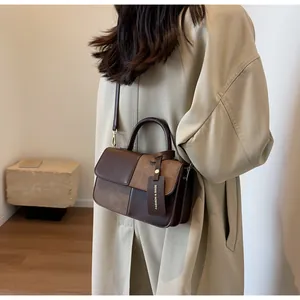 Bolso bandolera de cuero marrón con textura de ante sobre gabardina beige