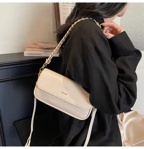 Cream baguette bag with NO FILTER print and metal chain strap on model's shoulder