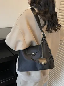 Minimalistische zwarte nylon en lederen draagtas op model voor een stijlvolle woon-werk