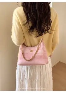 Détail du sac sous l'aisselle en tweed rose et cuir avec bandoulière chaîne dorée