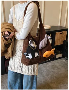 Sac cabas marron en peluche avec patch chat et breloques poisson porté par un mannequin