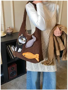 Gros plan du sac fourre-tout marron en peluche avec broderie chat et breloques poisson
