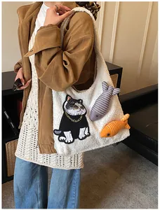 Détail du sac cabas en peluche blanche avec broderie chat et breloques en forme de poisson