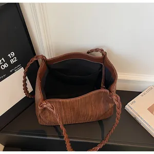Vue détaillée du sac cabas marron vintage avec anses tressées et intérieur en tissu noir