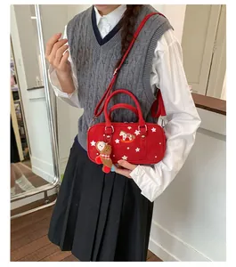 Detail of red Boston bag with star patterns and cute plush bear charm on model