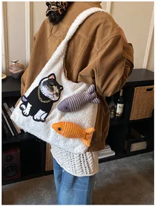 Détail du sac cabas en peluche blanche avec broderie chat et pendentifs poissons rayés